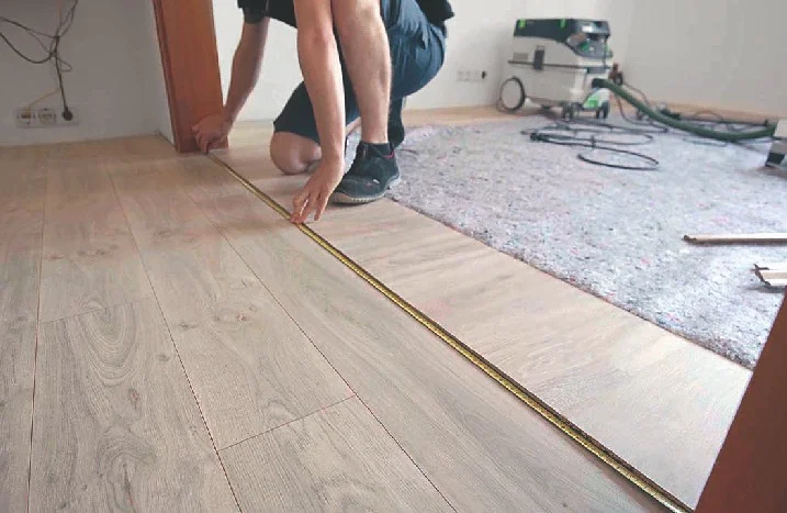 Person verlegt Holzlaminat